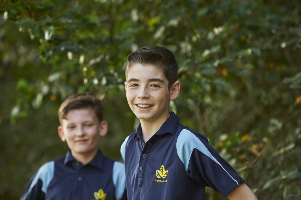 Two Longfield Academy students in PE kits smile for the camera.