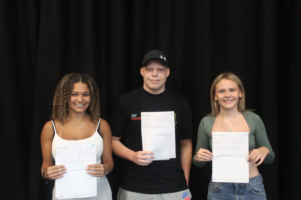 Three students holding their results